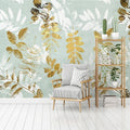 Papier peint feuilles dorées et blanches sur fond vert d'eau, fauteuil gris