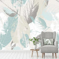 Papier peint panoramique de grandes feuilles bleu pastel et beige dans un salon