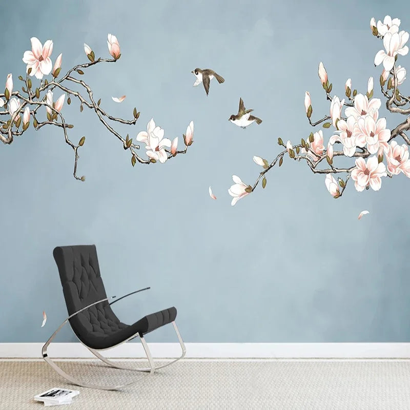 Branches de magnolia fleuries et deux oiseaux sur fond bleu gris, fauteuil noir
