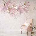 Mur orné d'une branche de magnolias roses aquarellés, fauteuil rose et guéridon doré