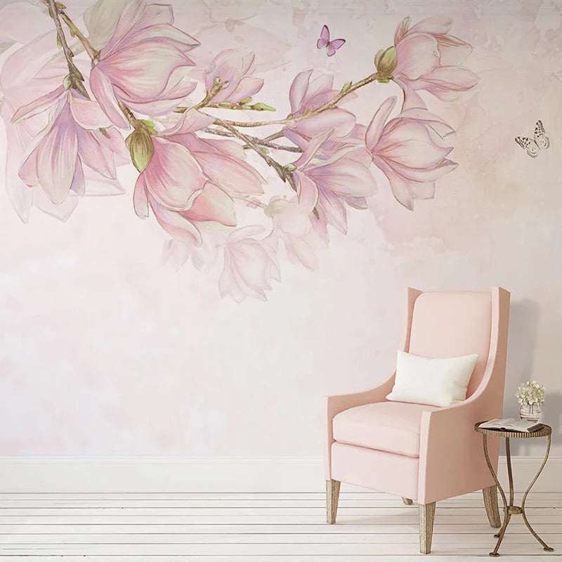 Mur orné d'une branche de magnolias roses aquarellés, fauteuil rose et guéridon doré