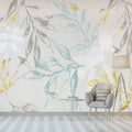 Papier peint panoramique feuillages bleus, gris et dorés dans un salon clair