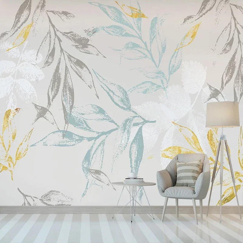 Papier peint panoramique feuillages bleus, gris et dorés dans un salon clair