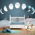 Chambre d'enfant avec mur décoré des phases de la lune sur ciel étoilé bleu