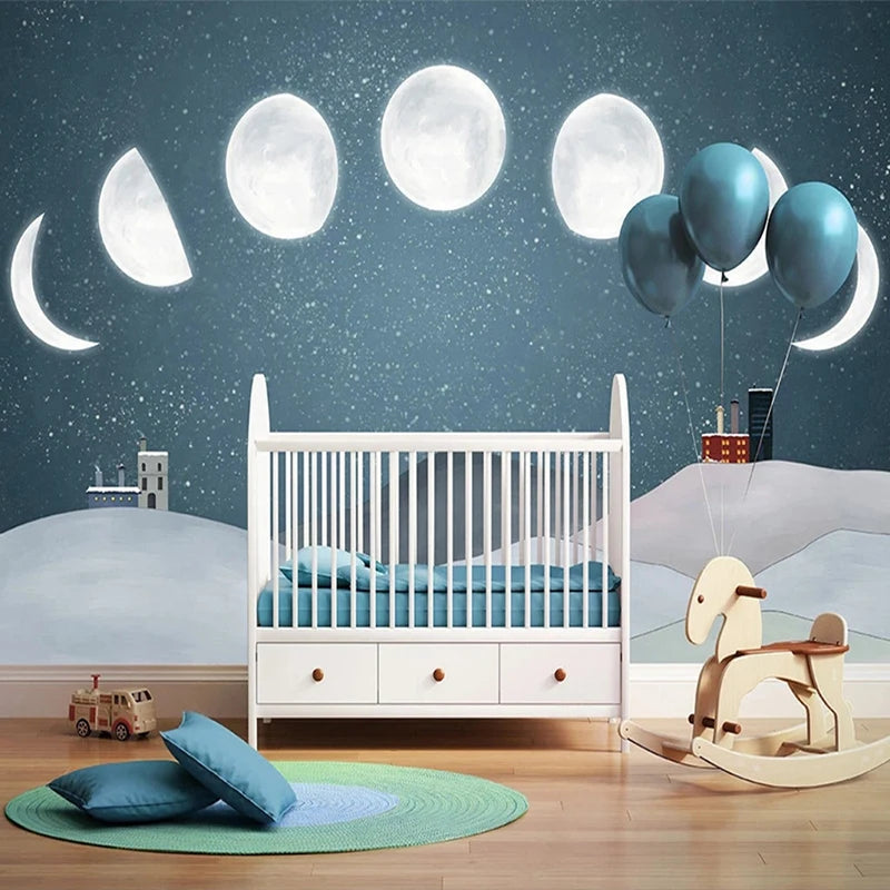 Chambre d'enfant avec mur décoré des phases de la lune sur ciel étoilé bleu