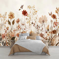Papier peint panoramique de fleurs sauvages beige et terracotta avec papillons, derrière un lit