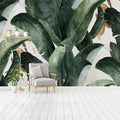 Mur de salon orné de grandes feuilles de bananier vertes peintes à l'aquarelle
