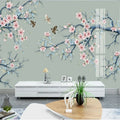 Branches de prunier en fleurs roses et oiseaux sur fond vert sauge, salon