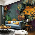 Papier peint panoramique feuilles tropicales ocre et vertes dans un salon avec canapé bleu