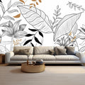 Papier peint feuillage tropical au trait noir et blanc derrière un canapé beige