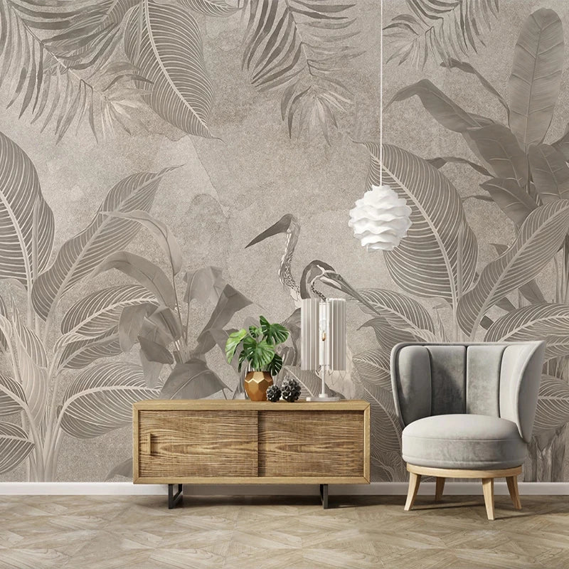 Papier peint panoramique feuillages tropicaux beige et gris avec hérons dans un salon