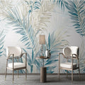 Salon avec papier peint panoramique de palmes aquarelle bleues et beiges, fauteuils blancs
