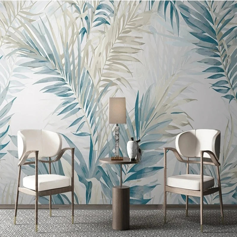 Salon avec papier peint panoramique de palmes aquarelle bleues et beiges, fauteuils blancs