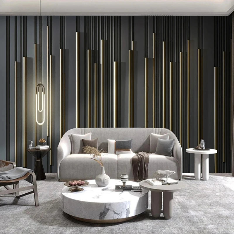 Mur de salon orné de rayures verticales grises et dorées derrière un canapé clair