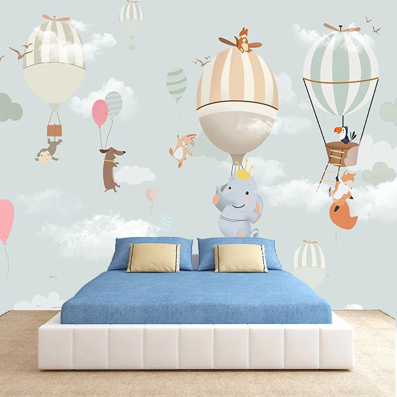 Mur de chambre d'enfant orné de montgolfières, nuages et animaux sur ciel bleu pâle
