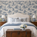 Chambre avec papier peint toile de Jouy bleue à scènes champêtres derrière le lit